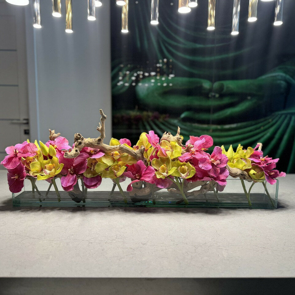 Moderne Haus-Glasvase mit pinkfarbenen Vanda-Orchideen und grünen Cymbidien