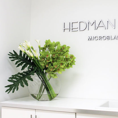 Lunar Vase mit grünen Cymbidien und Callas